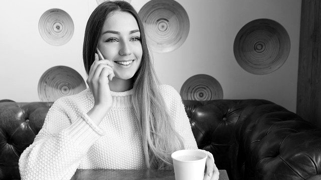 笑顔で電話をする女性 カフェ スマホ